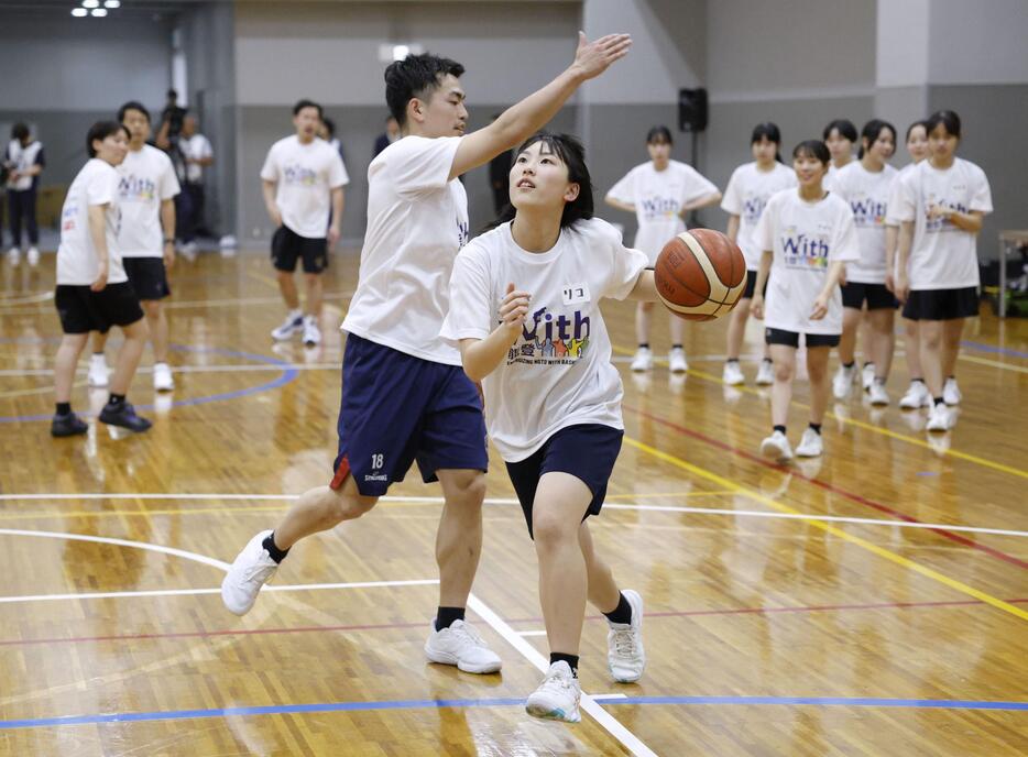 バスケットボールBリーグ横浜BCの森井健太選手（左）の指導を受ける、能登半島地震被災地の中学生上杉理子さん＝25日、横浜アリーナ