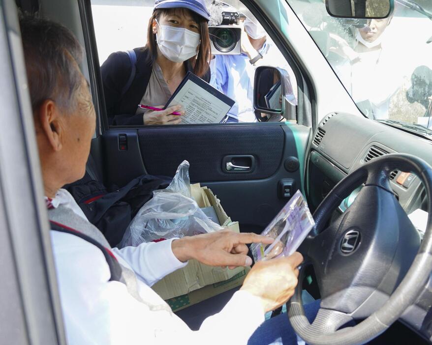 チラシを配布し、吉川友梨さんの情報提供を求める大阪府警の捜査員（奥）＝21日午後、大阪府熊取町