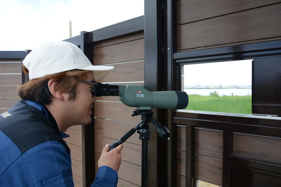 貸し出し用の望遠鏡で野鳥を観察するネイチャーガイド