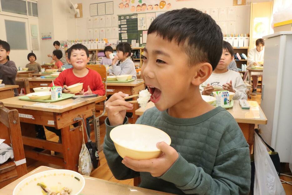 有機米給食のごはんをほおばる児童＝2023‎年‎12‎月‎、兵庫県丹波市内で