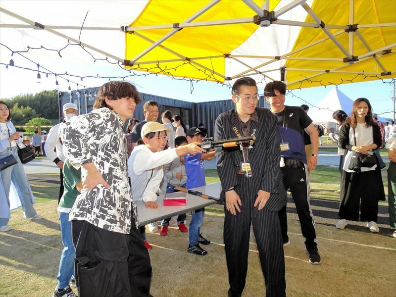 射的コーナーで来場者を盛り上げる黒須さん（左から３人目）ら大学生