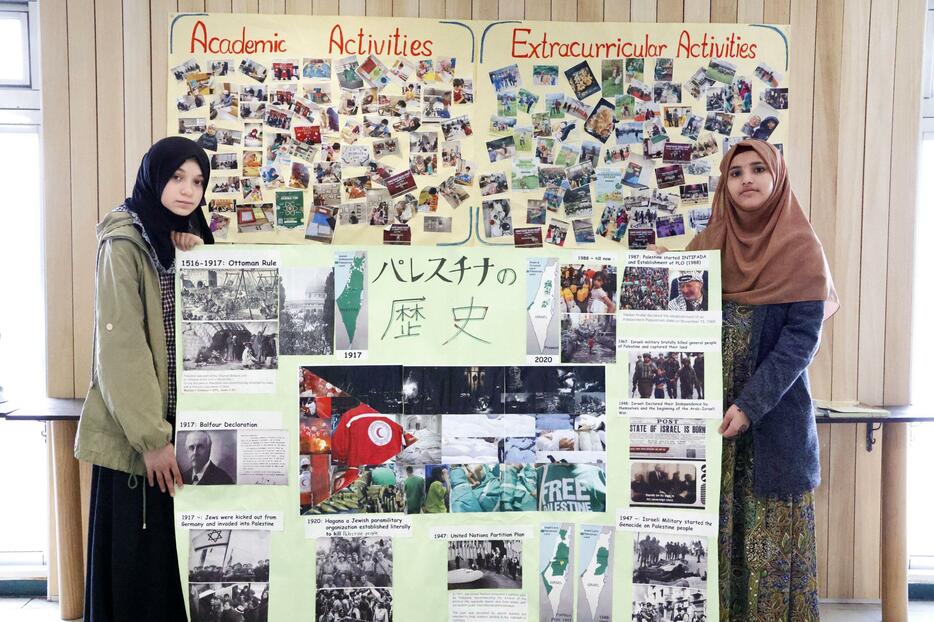 パレスチナの歴史や現状を表現したポスターを手に記念撮影するサッポロ・イスラミック・インターナショナル・スクールの生徒＝16日午前、札幌市