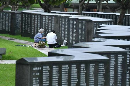 （資料写真）平和の礎に手を合せて沖縄戦でなくなった親族の冥福を祈る親子