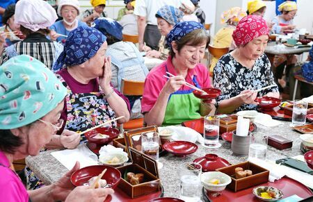 プロに教わり作った日本料理を味わう本部町老人会のメンバー＝１８日、同町・もとぶ元気村