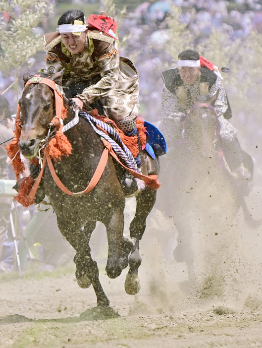 「相馬野馬追」の甲冑競馬で、土ぼこりを上げて疾走する騎馬武者＝26日午後、福島県南相馬市