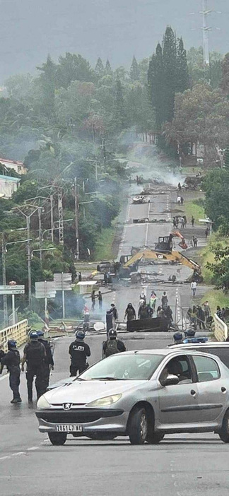 15日、暴動が続くニューカレドニア・ヌメアの壊された道路と配置に就く当局者ら（Lilou　Garrido　Navarro　Kherachi提供・ロイター＝共同）