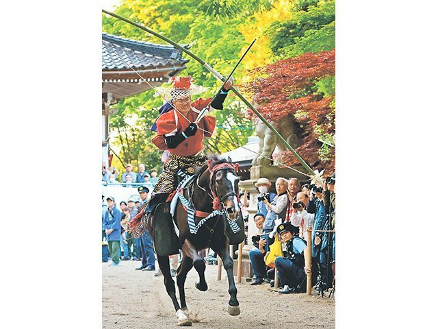 大勢の人が見守る中、疾走する馬から矢を射る男性＝加茂神社
