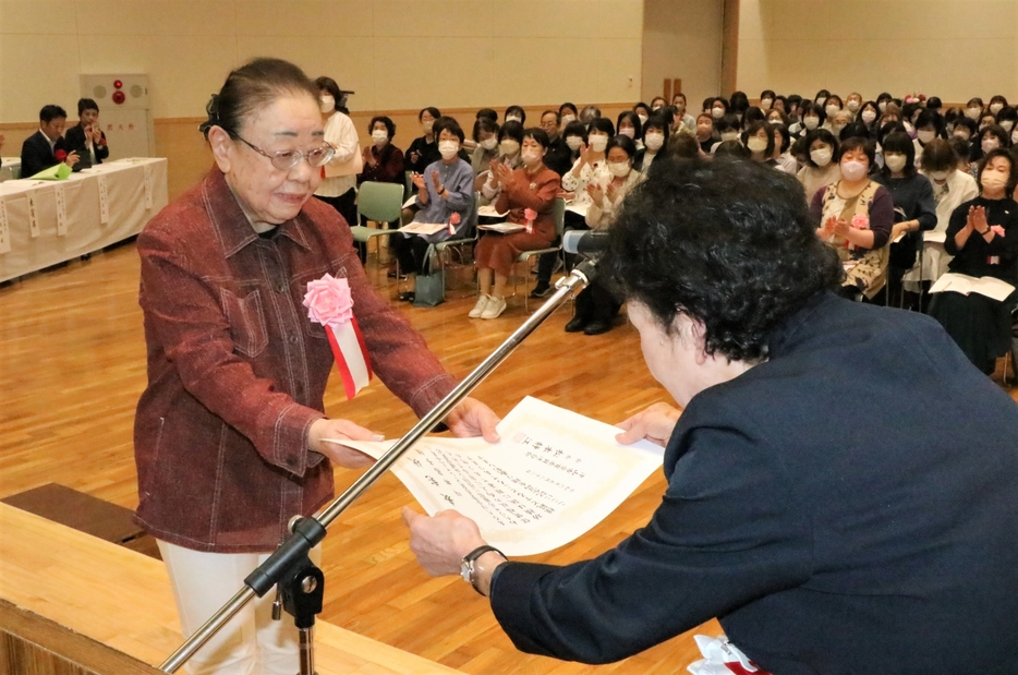 松本会長から特別表彰を受け取る委員（左）=岡山県津山市で