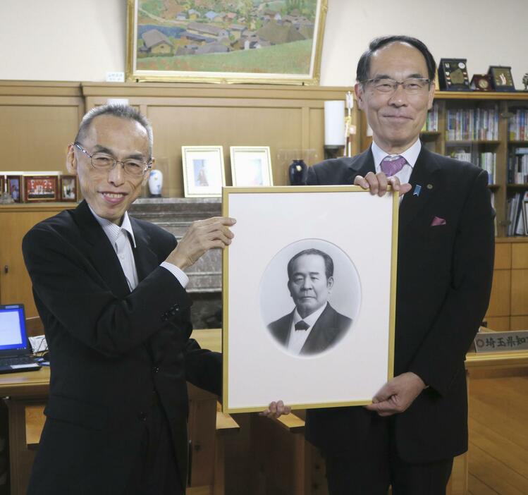 新1万円札に印刷される渋沢栄一の肖像画の複製を国立印刷局の大津俊哉理事長（左）から贈呈された埼玉県の大野元裕知事＝31日午後、埼玉県庁