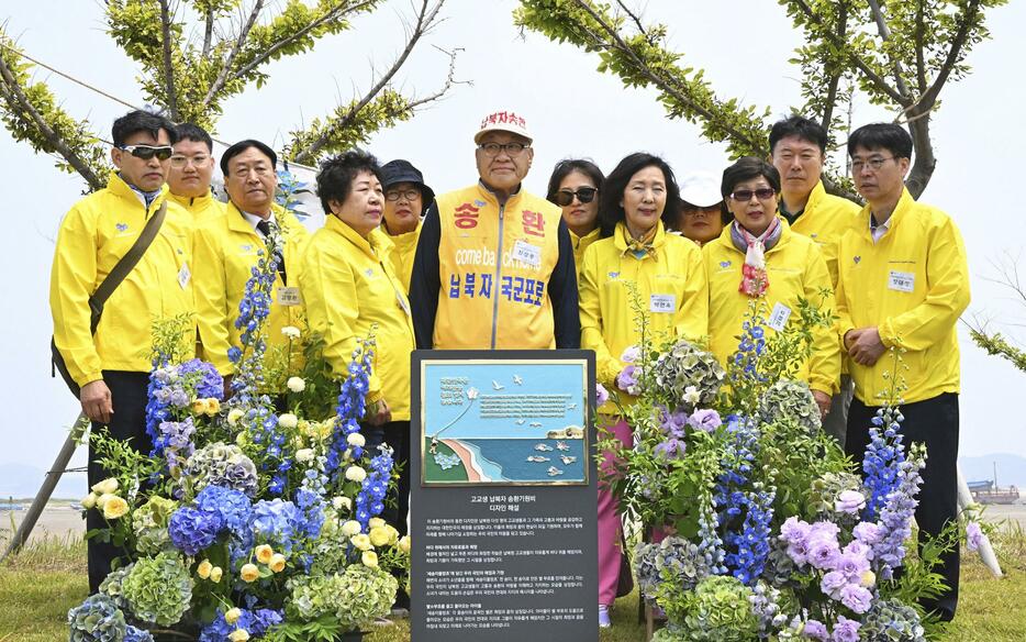 24日、韓国南西部・仙遊島に設置されたモニュメントを前に写真に納まる韓国人拉致被害者の家族ら（共同）