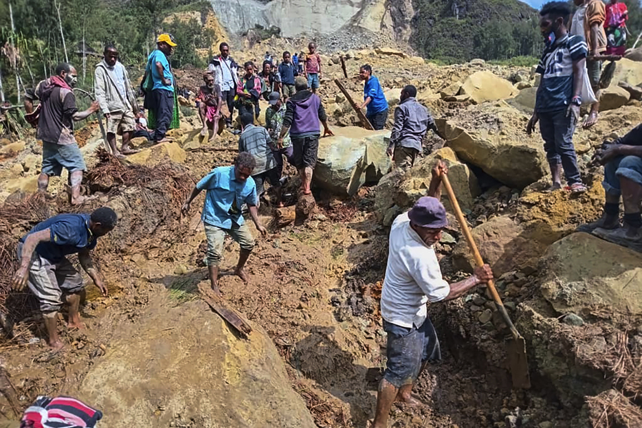 26日、パプアニューギニア・エンガ州の地滑り現場で捜索する人々（IOM提供・AP＝共同）