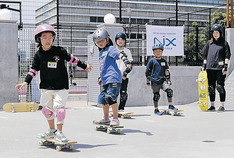 スケートボードに乗る児童＝富山市湊入船町