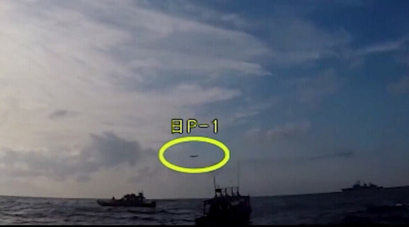 2018年12月20日、遭難船の救助作戦中の駆逐艦「広開土大王」の上空に低高度で威嚇飛行をする日本の哨戒機（黄色い円）。国防部が2019年1月に公開した映像＝韓国国防部のユーチューブチャンネルより