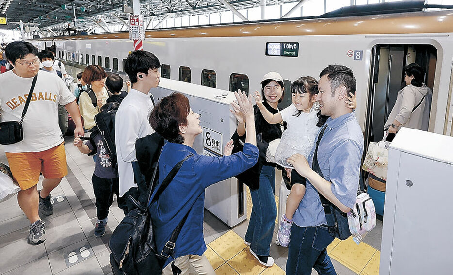 親族に見送られ、新幹線に乗り込む家族＝富山駅