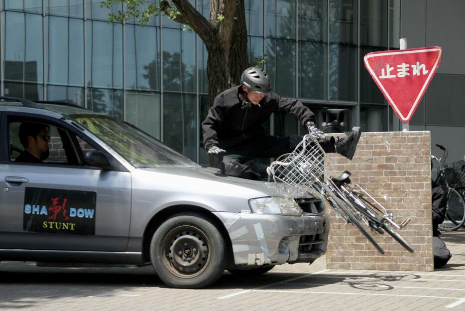 スタントマンによる自転車と車の事故の実演＝24日午後、東京都世田谷区の日本体育大のキャンパス