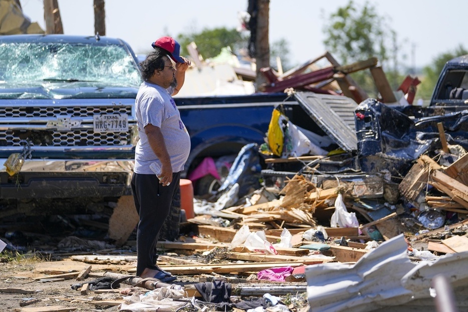 竜巻が起きた米テキサス州でがれきを見つめる男性＝26日（AP＝共同）