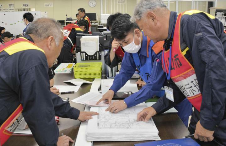 図上訓練で、被害場所を地図で特定する松山市職員ら