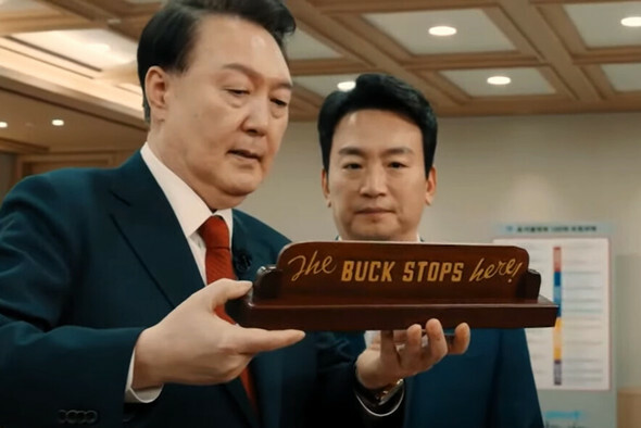 尹錫悦大統領が2月7日、「韓国放送（KBS)」の新年特別対談に先立ち、「The buck stops here」（すべての責任は私が取る）と書かれた机の上の木札を持ち上げて見せている＝KBSの画面よりキャプチャー