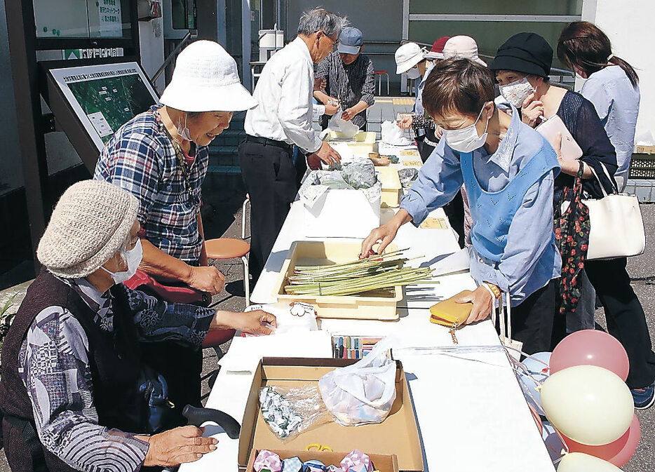 初めて開かれた朝市で、農産品などを買い求める住民＝羽咋市の旧余喜公民館前