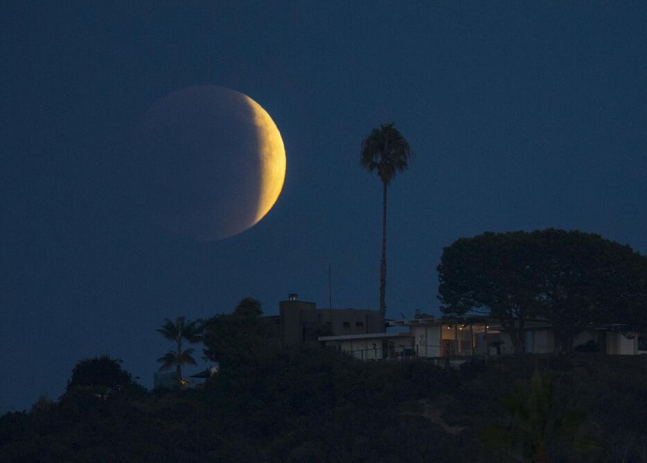 カリフォルニアのソラーナ・ビーチの丘にかかる大きく欠けた月＝2015年9月27日（写真：ロイター/アフロ）