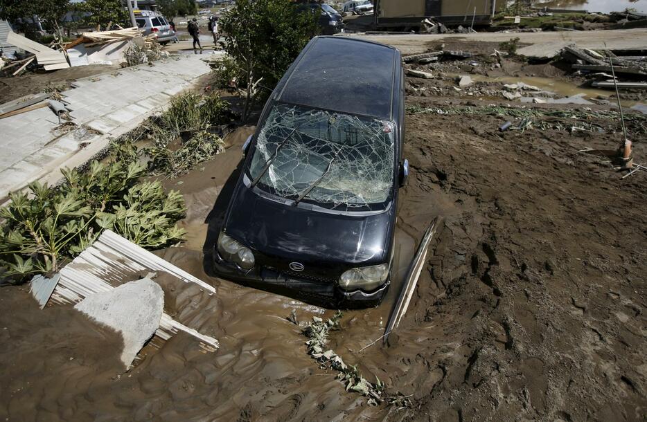 泥に埋まった車＝2015年9月11日（写真：ロイター/アフロ）