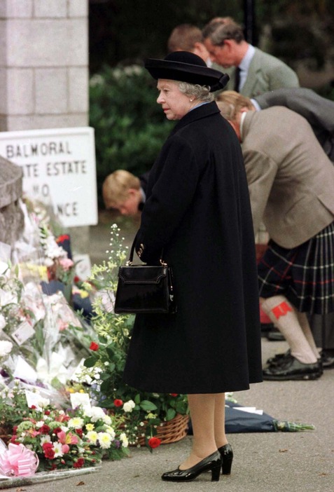 ダイアナ元皇太子妃が交通事故で死去。手向けられた花を見つめるエリザベス女王＝1997年9月4日（写真：ロイター/アフロ）