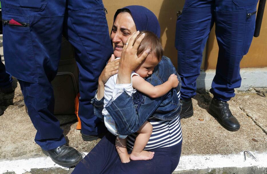 子どもを抱く移民の女性＝2015年9月3日（写真：ロイター/アフロ）