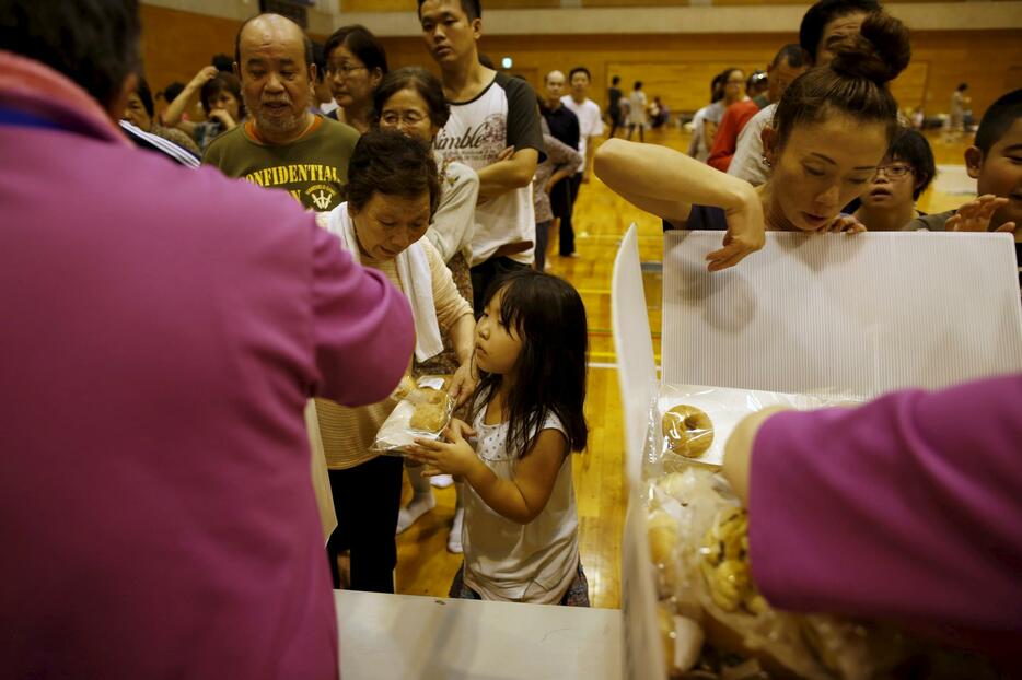 避難所で食料を受け取る子ども＝2015年9月10日（写真：ロイター/アフロ）