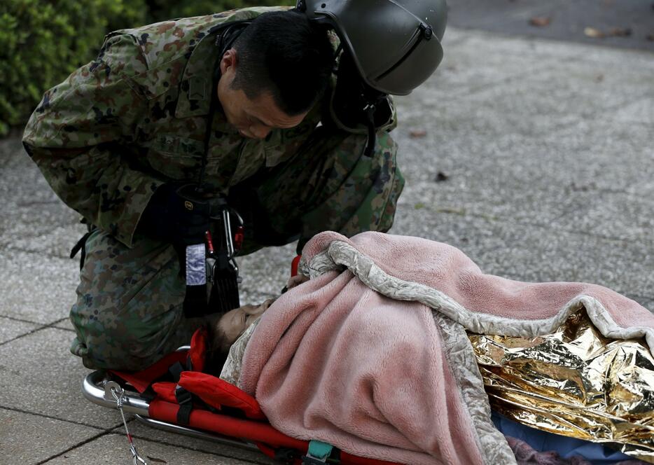 救助された女性に話しかける自衛隊員＝2015年9月10日（写真：ロイター/アフロ）