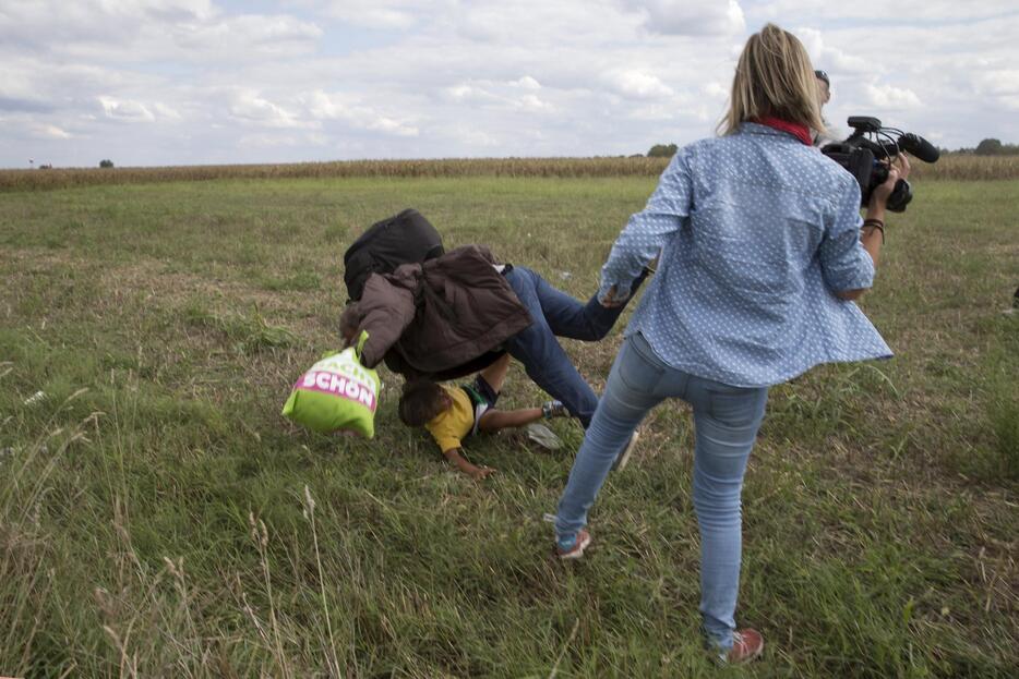 足を突き出す女性カメラマン＝2015年9月8日（写真：ロイター/アフロ）