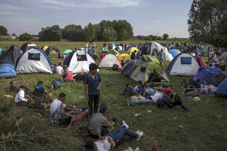 国境付近にテントを張り、体を休める難民＝2015年9月15日（写真：ロイター/アフロ）