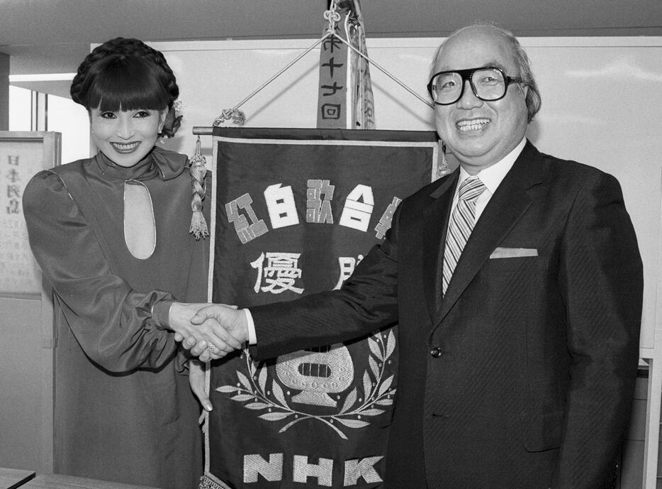 1983年11月、NHK紅白歌合戦の司会に決まり黒柳徹子さん（左）と握手するアナウンサーの鈴木健二さん＝東京都渋谷区