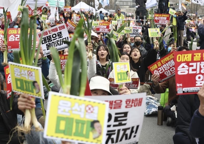 長ネギを掲げる反尹政権集会の参加者ら＝３月３０日、ソウル（聯合＝共同）