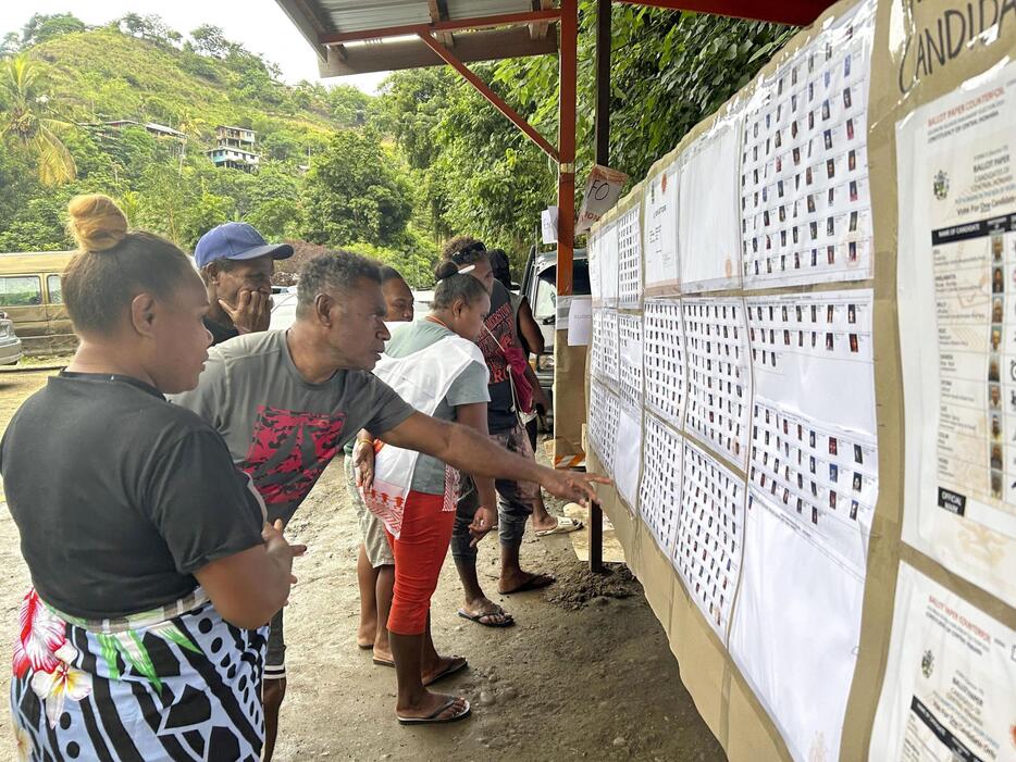 17日、ソロモン諸島ホニアラで総選挙の立候補者を見る有権者ら（共同）