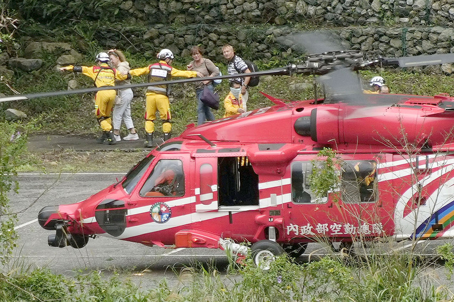 地震で孤立した地区から救助され、ヘリから降りる人たち＝6日、台湾東部・花蓮（共同）