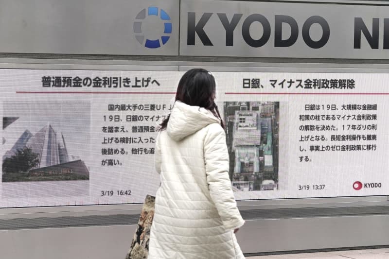 日銀がマイナス金利政策の解除を決めたニュースなどを伝える街頭モニター＝１９日午後、東京都港区
