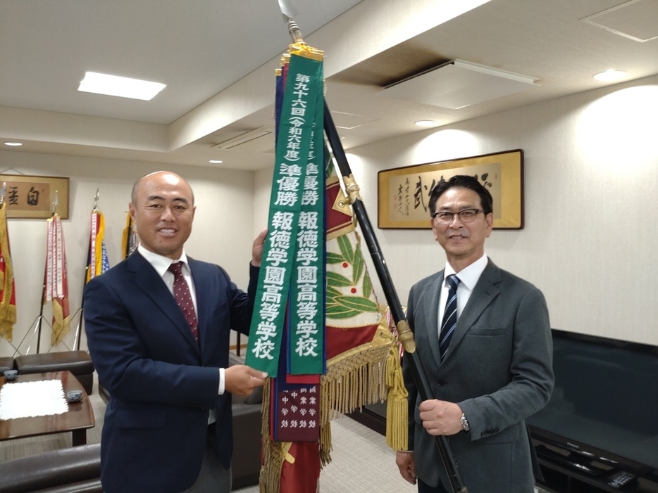 センバツ準優勝のペナントを手にする報徳学園の大角健二監督（左）と川口直彦校長＝兵庫県西宮市の同校で２０２４年４月２６日午後０時３５分、稲垣淳撮影