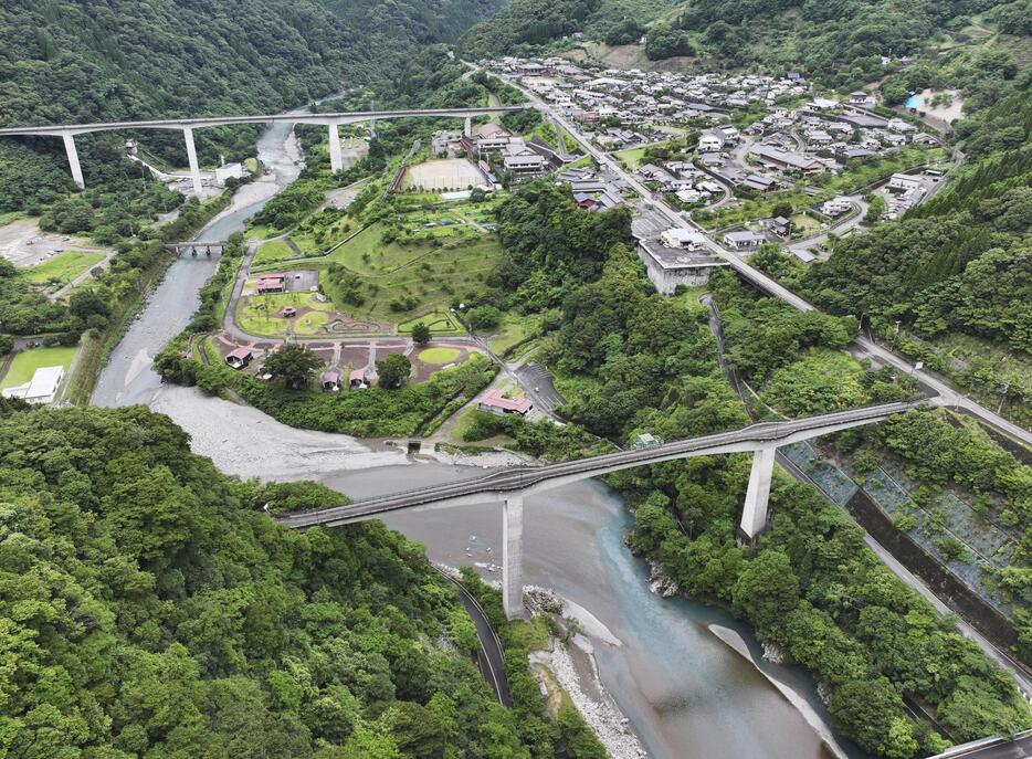 川辺川ダム建設に伴う水没予定地周辺。右上は、高台の代替地に移転した集落＝2023年6月、熊本県五木村（ドローンから）