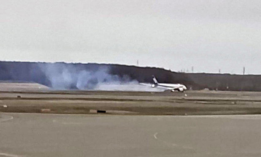 煙を出し着陸する全日空機＝24日午後、新千歳空港（マドリガル提供）