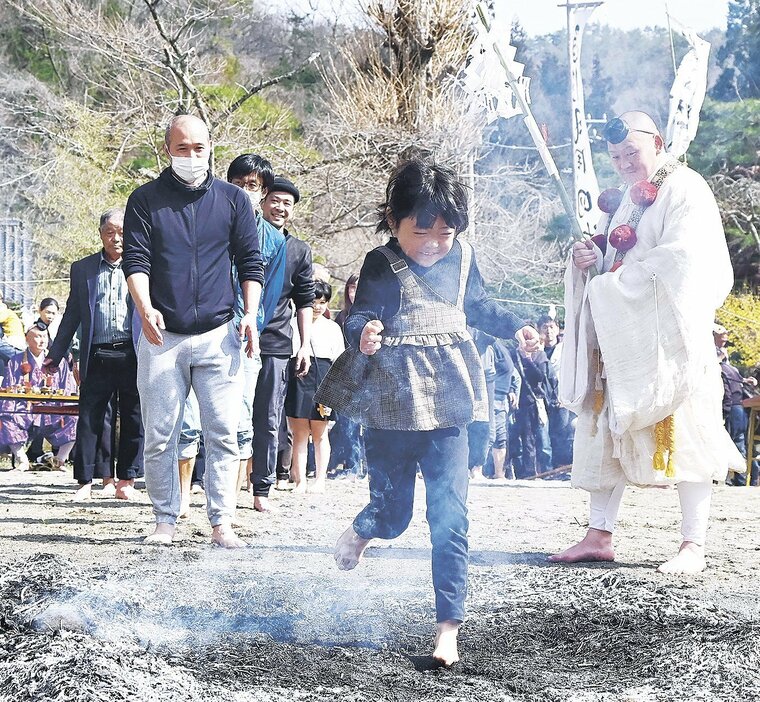 熱さが残る灰を踏む参拝者たち