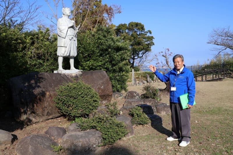 原城本丸跡に立つ天草四郎像と内山哲利さん＝２０２３年１２月２７日、長崎県南島原市