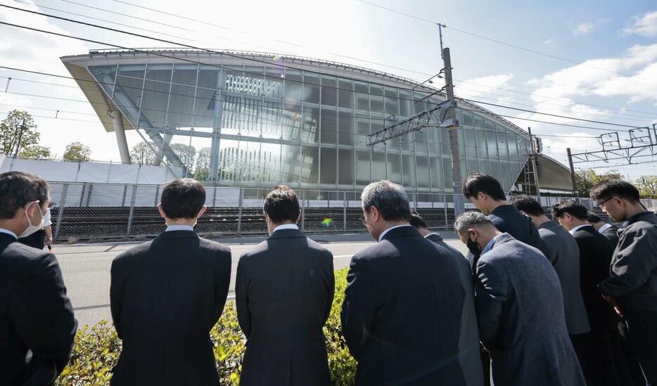 尼崎JR脱線事故の発生時刻に合わせ、「祈りの杜」の前で黙とうする人たち＝25日午前9時18分、兵庫県尼崎市