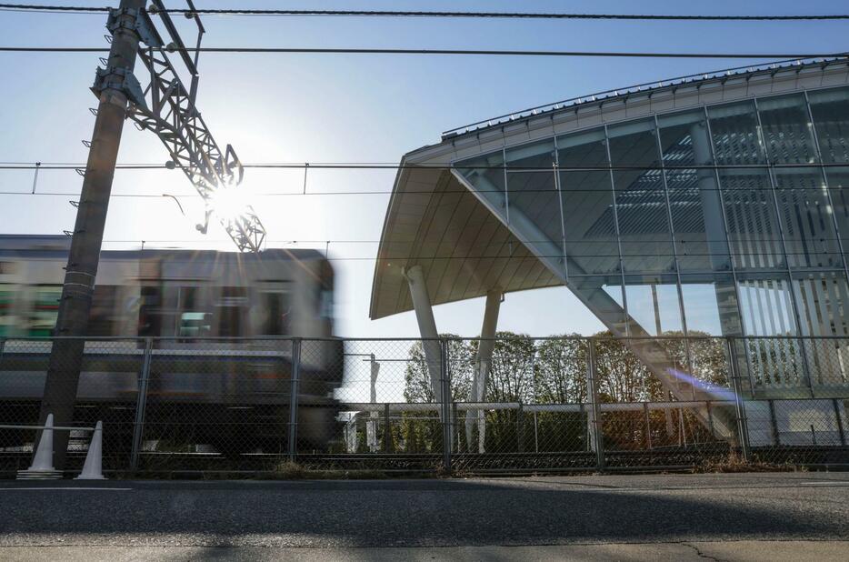 尼崎JR脱線事故の現場に整備された「祈りの杜」の横を通過する電車＝25日午前7時15分、兵庫県尼崎市