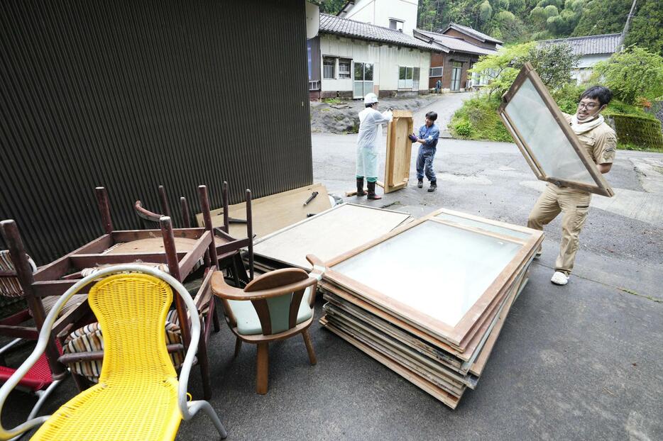 石川県輪島市の被災した家屋から家財道具を運び出すボランティア。北海道の村山卓さん（右）は「また観光できるようにまで輪島が復興してほしい」と汗を流した＝30日午後