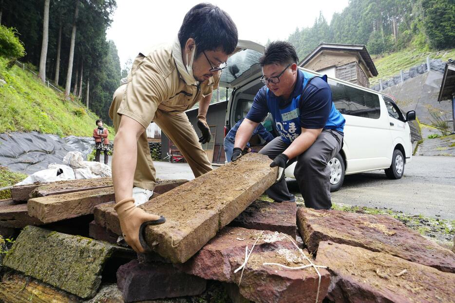 石川県輪島市の被災した家屋で搬出作業をするボランティア。北海道の村山卓さん（左）は「また観光できるようにまで輪島が復興してほしい」と汗を流した＝30日午後