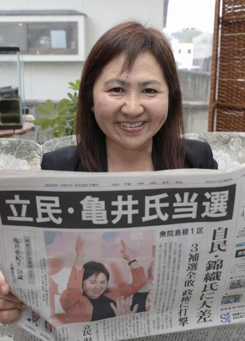 衆院島根1区補欠選挙の当選から一夜明け、新聞を手にする亀井亜紀子氏＝29日午前、松江市