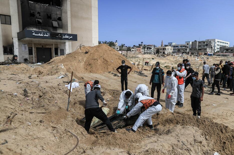 ナセル病院敷地の「集団墓地」に埋められた遺体の収容作業を続けるガザ当局のチーム＝21日、ガザ地区南部ハンユニス（ゲッティ＝共同）