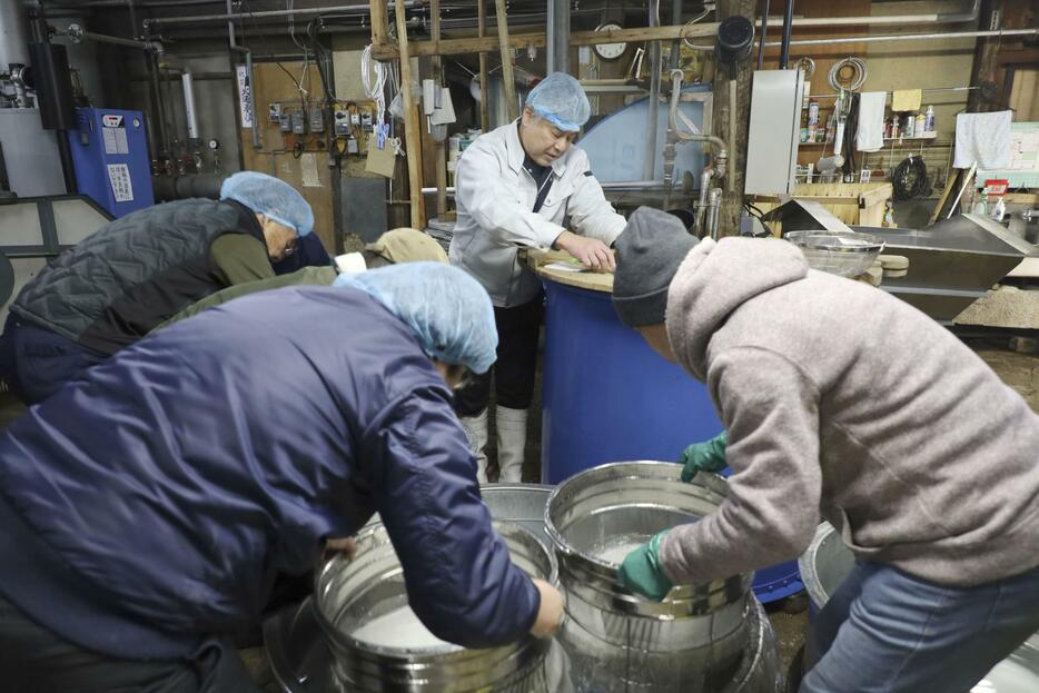 吉田酒造で日本酒の仕込みをする「夢酒蔵」のメンバーら＝2024年1月、滋賀県高島市