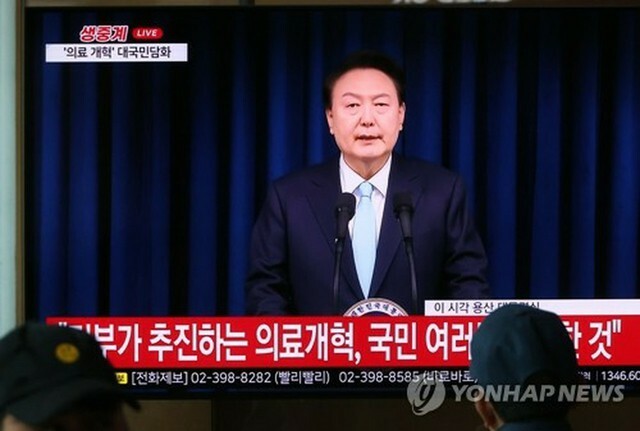 尹大統領が国民向けの談話を発表する様子をソウル駅のテレビで見ている市民ら＝1日、ソウル（聯合ニュース）