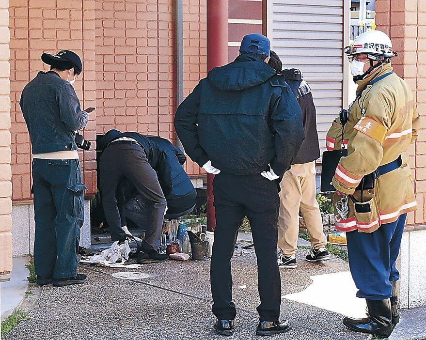 火が付けられたとみられるごみを調べる捜査員＝１０日午前１０時２０分、金沢市寺地２丁目